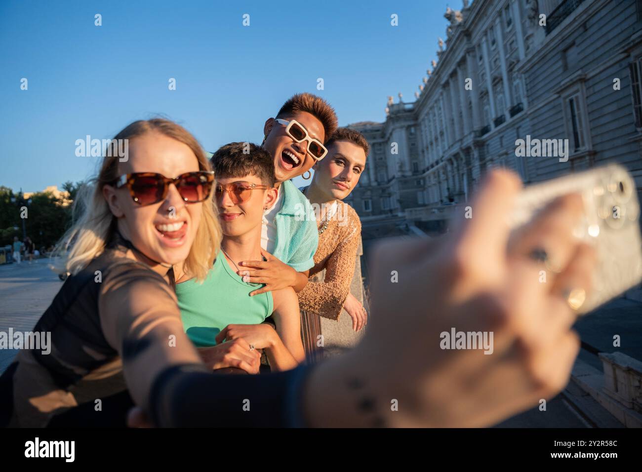 Eine Gruppe von LGBTQIA+ Freunden hält einen freudigen Selfie-Moment an einem sonnigen Tag in der Stadt fest, in der Nähe der von der Natur inspirierten Street Art in . Stockfoto
