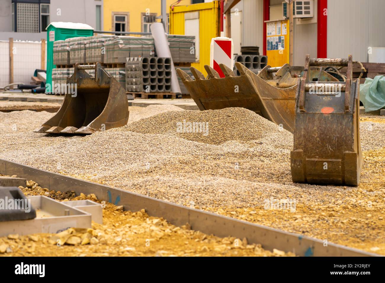 Der Baggerlöffel nimmt zerquetschten Stein für Straßenreparaturen auf Stockfoto
