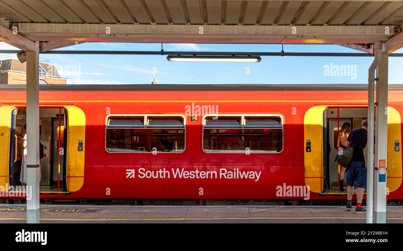 Personen, die an der Clapham Junction Railway Station in South West London, Großbritannien, in einen Zug der South Western Railway steigen Stockfoto