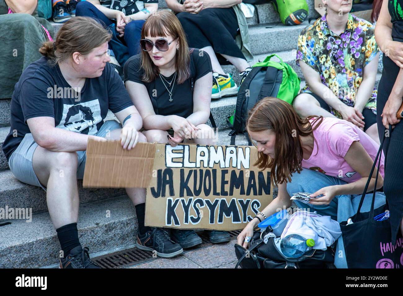 Elämän ja kuoleman Kysymys. Demonstranten sitzen auf der Treppe des Parlamentsgebäudes bei der Myrskyvaroitus-Demonstration von Elokapina in Helsinki, Finnland Stockfoto