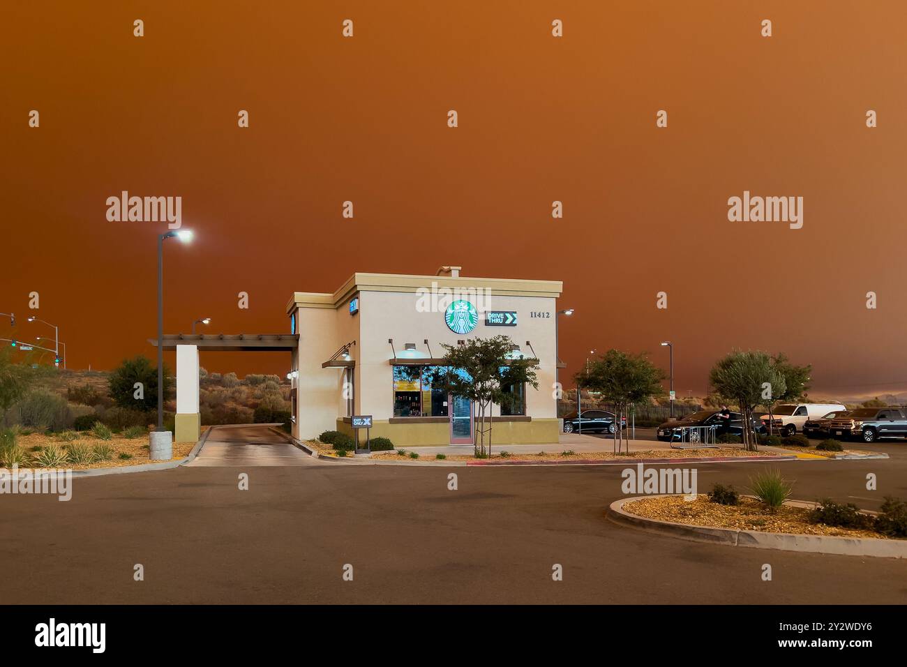 Hesperia, KALIFORNIEN, USA - 10. September 2024: Rauch aus Bränden in den Südkalifornischen Bergen erzeugt einen orangen Himmel in der Mojave-Wüste. Stockfoto