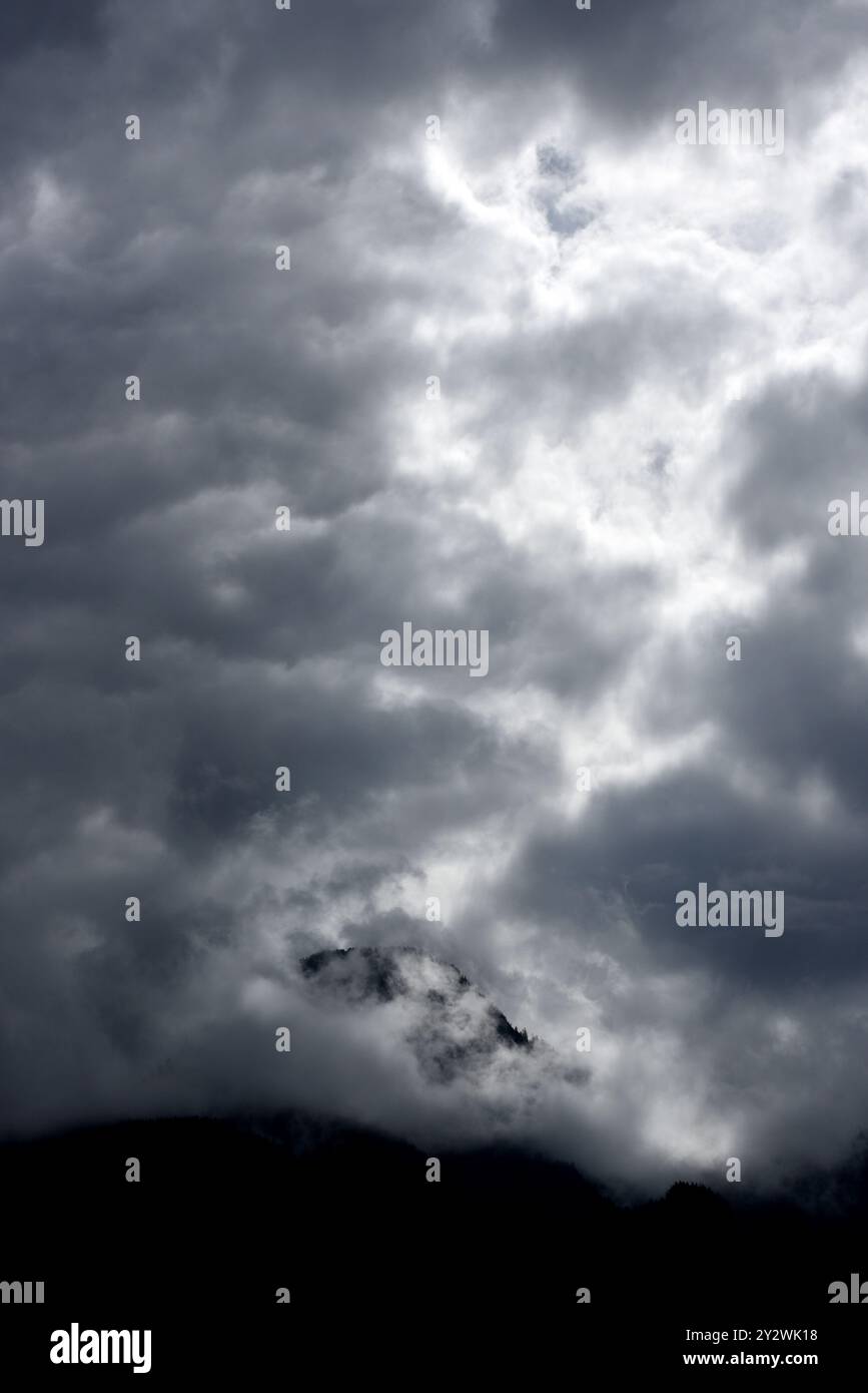 Die Sonne leuchtet hinter Wolken über einem Berggipfel in British Columbia, Kanada Stockfoto