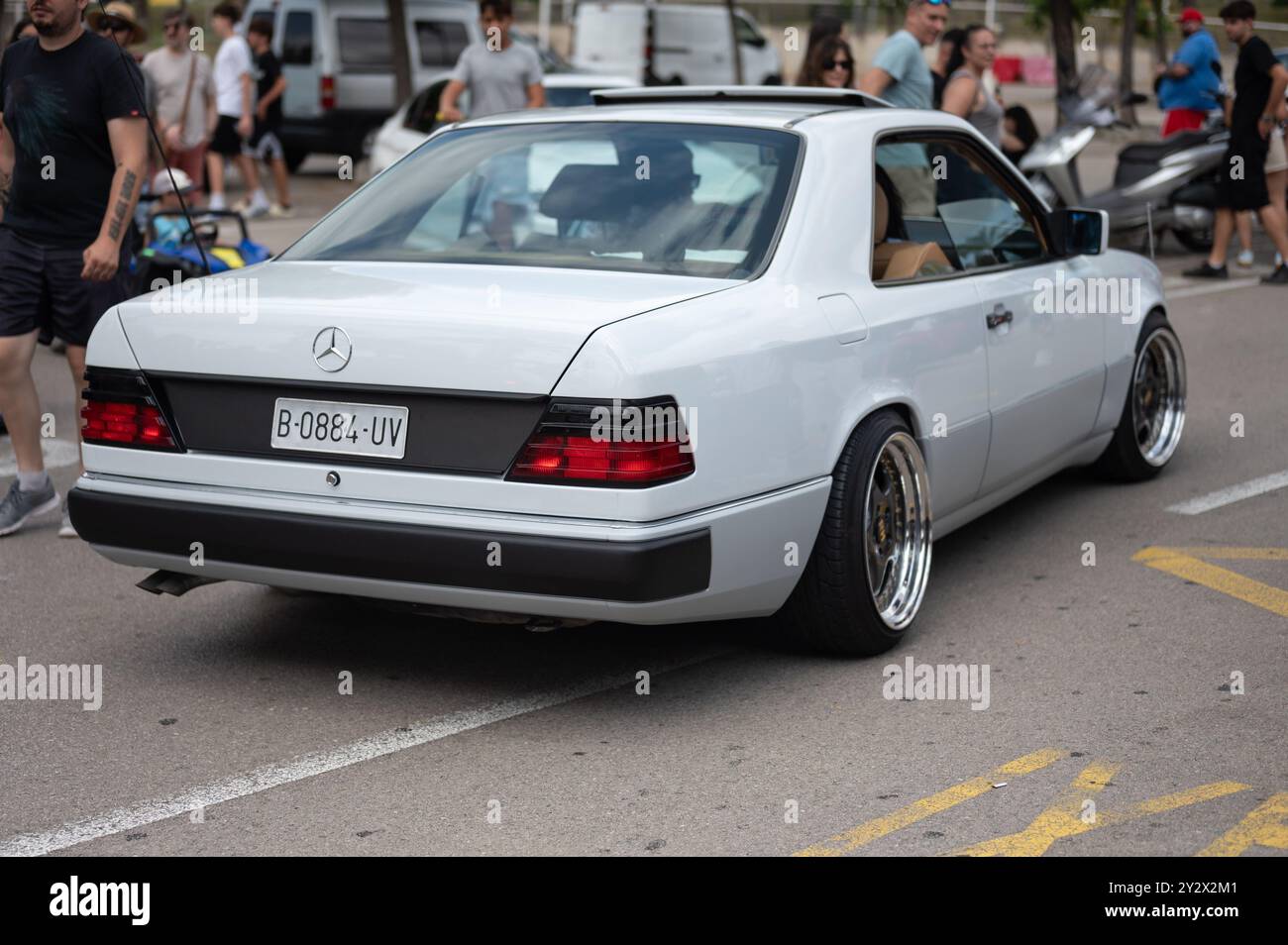 Rückansicht eines spektakulären weißen Mercedes Benz C124 Coupés, ein klassischer deutscher Luxus-Sportwagen, der mit großen und verchromten Rädern restauriert wurde Stockfoto