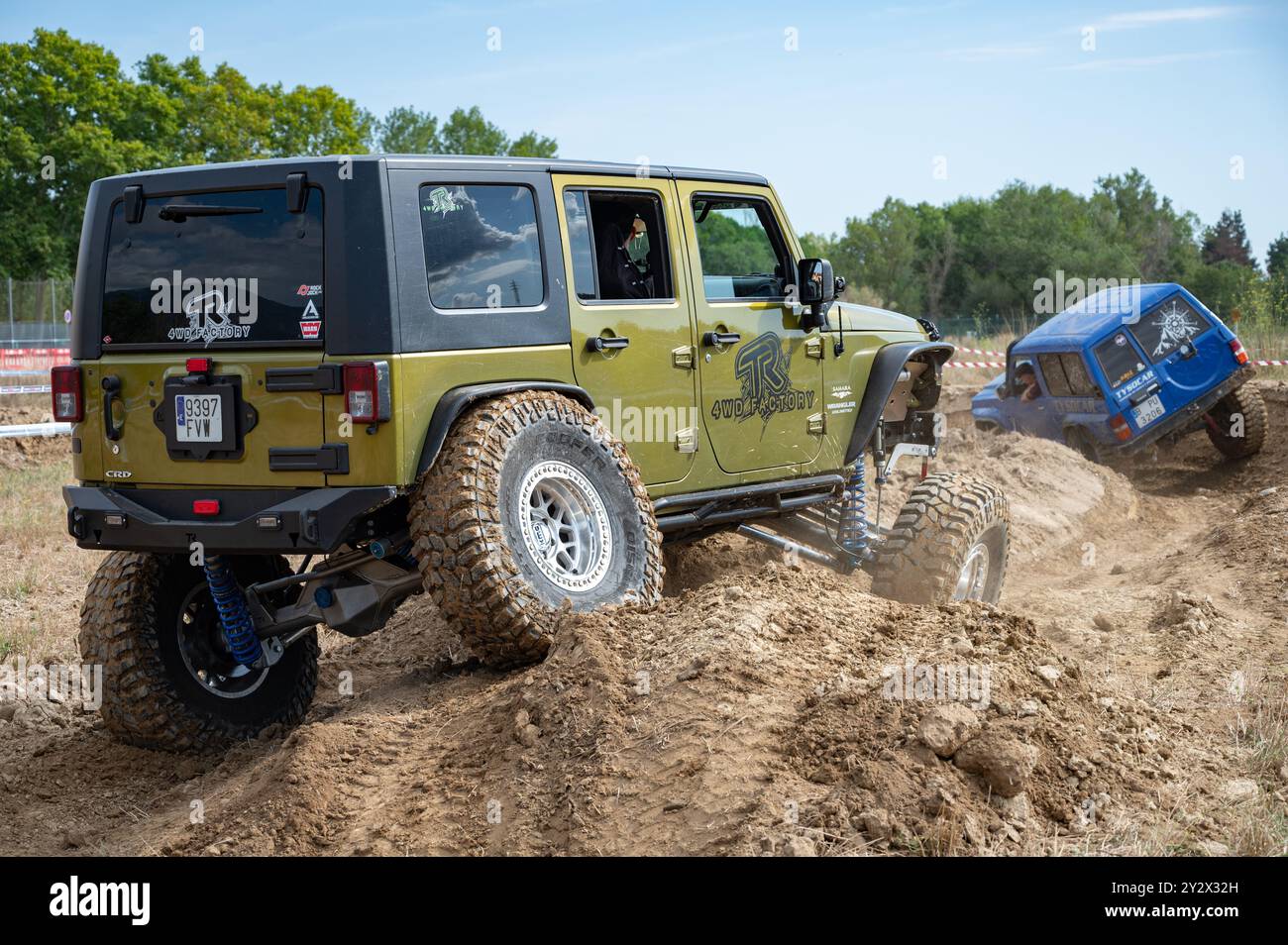 Es handelt sich um einen gelben Jeep Wrangler JK 2,8 CRD Turbodiesel Unlimited Sahara, der das Hindernis überwindet, Achsen und Federwege zu überqueren Stockfoto