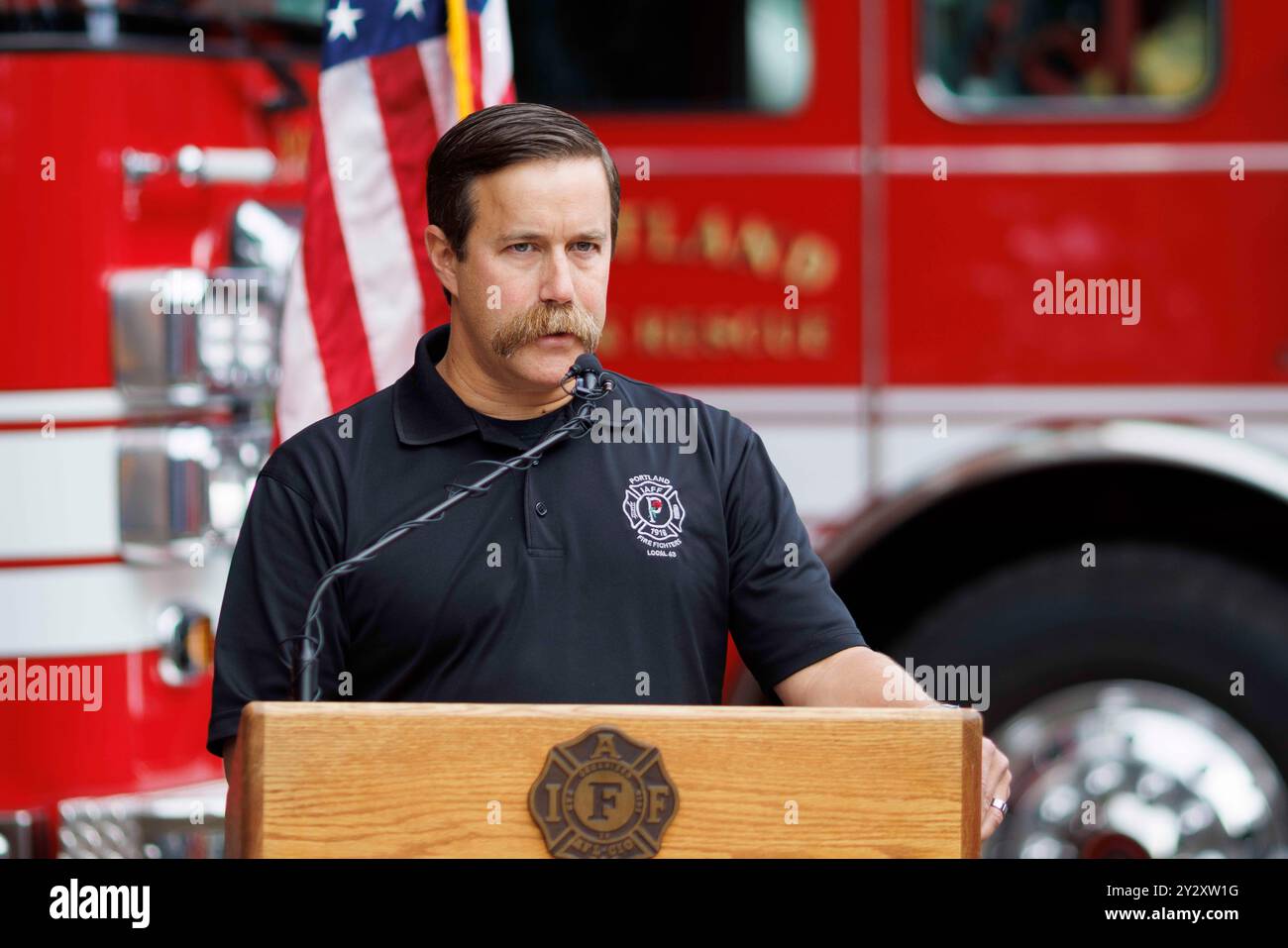 Portland, USA. September 2024. Isaac McLennan, Präsident der Portland Fire Fighters Local 43, spricht zu der Versammlung. Portland Fire and Rescue, das Feuerwehrbüro von Portland, Oregon, erinnert jährlich an das Heldentum der Feuerwehr von New York während der Angriffe vom 11.09.2001, bei denen über 300 Feuerwehrleute auf einmal gefordert wurden und viele weitere töteten, als nachfolgende Krankheiten das Leben forderten. (Foto: John Rudoff/SIPA USA) Credit: SIPA USA/Alamy Live News Stockfoto