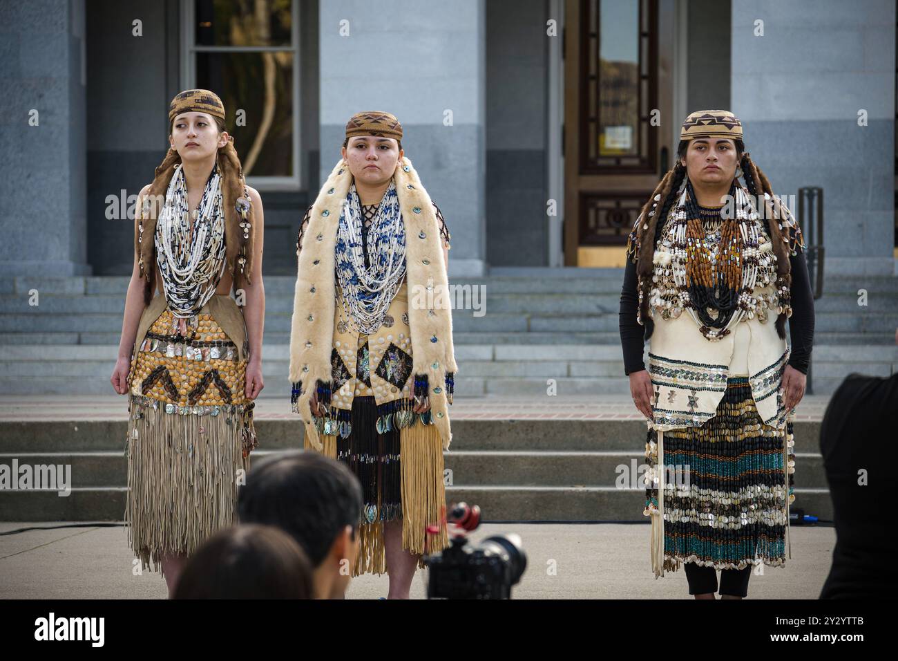 Drei junge weibliche Teilnehmer stehen feierlich am Aktionstag der vermissten und ermordeten Indigenen Stockfoto