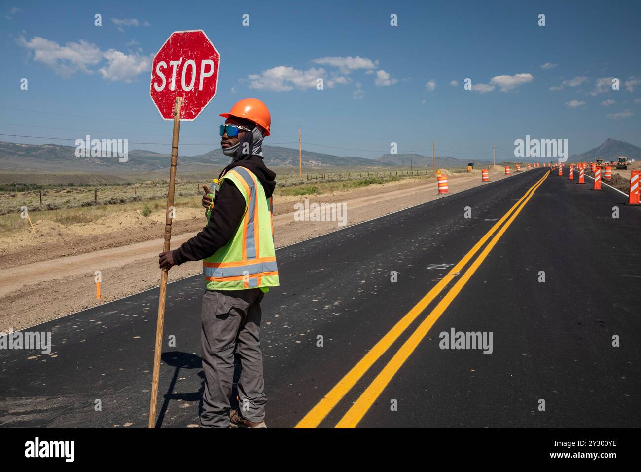 Kremmling, Colorado – Ein Straßenarbeiter stoppt den westwärts gerichteten Verkehr auf der U.S. Route 40, wo die Bauarbeiten die Straße auf eine Spur reduziert haben. Stockfoto