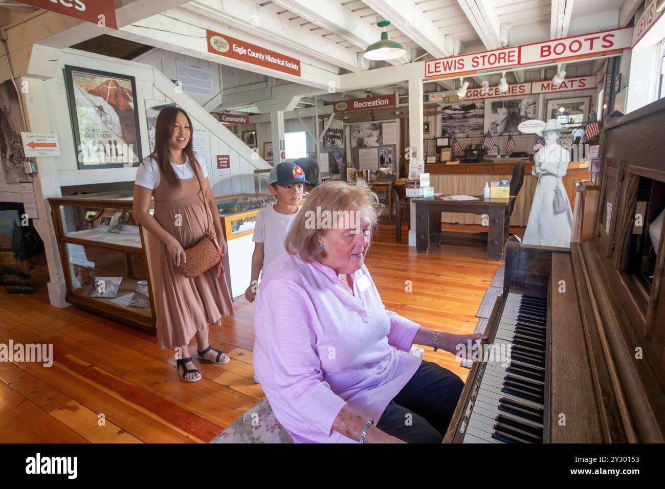 Eagle, Colorado - Das Eagle County Historical Museum. Ein Museumsarbeiter betreibt ein Klavier für Besucher. Stockfoto