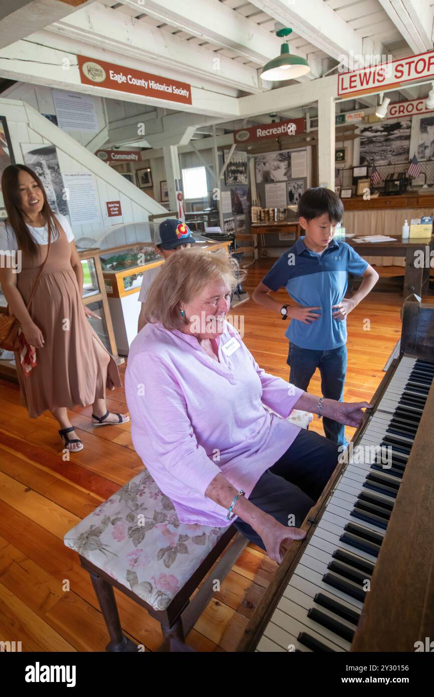Eagle, Colorado - Das Eagle County Historical Museum. Ein Museumsarbeiter betreibt ein Klavier für Besucher. Stockfoto
