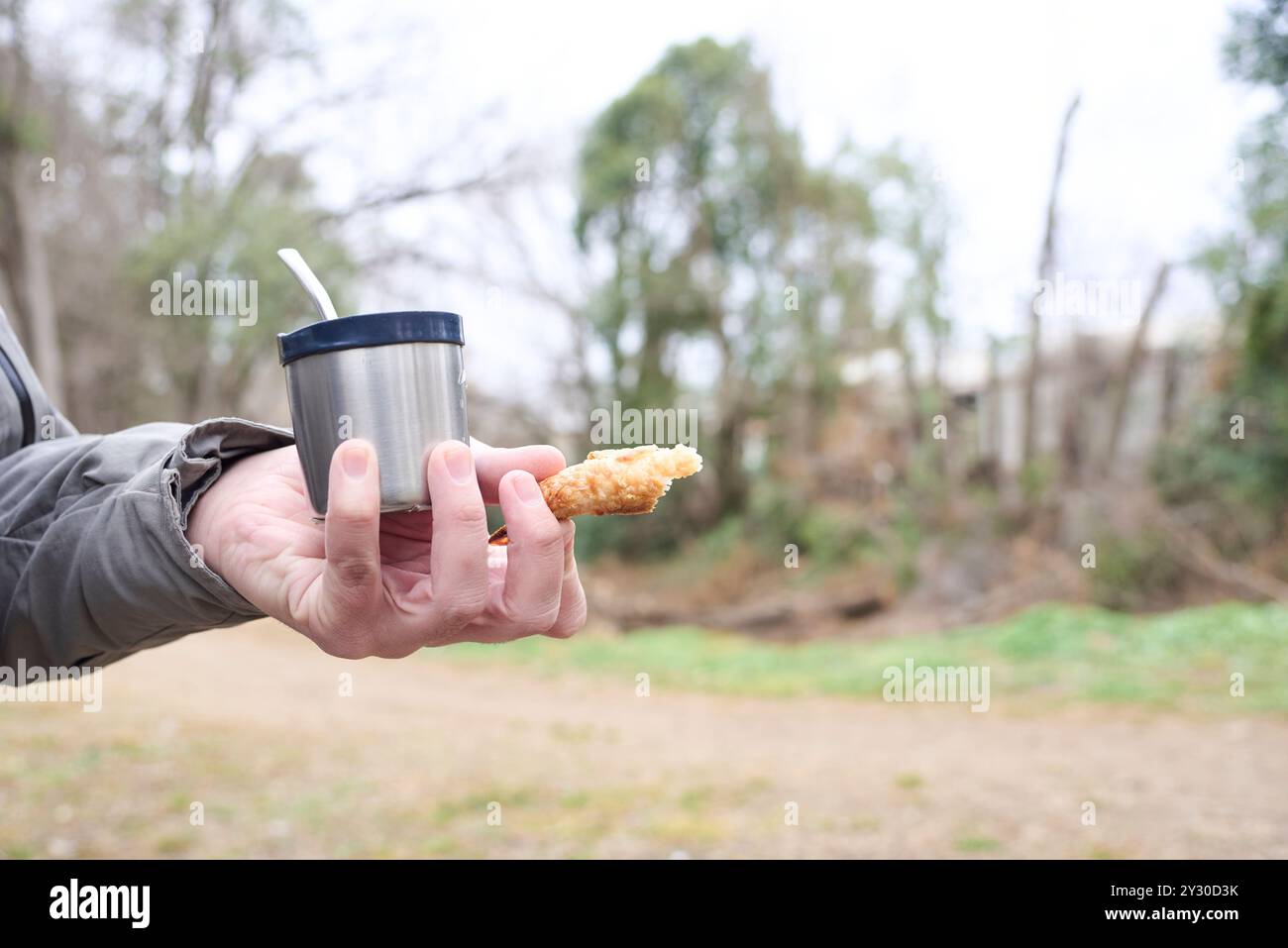 Hand einer nicht erkennbaren Person, die an einem kalten Wintermorgen draußen einen Freund und ein Stück Croissant hält. Komposition mit selektivem Fokus und Kopie Stockfoto