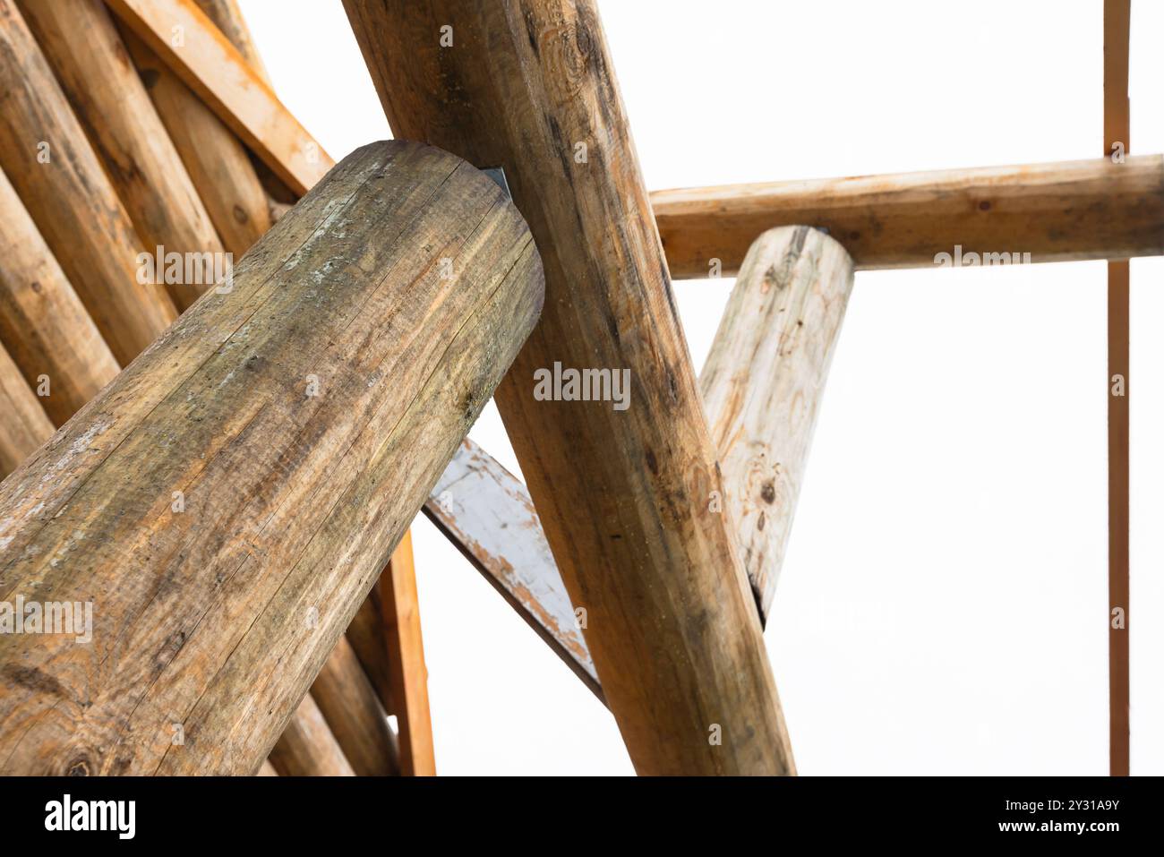 Ländliches Holzhaus aus Baumstämmen ist im Bau, Nahaufnahme von Holzteilen unter hellem Himmel Stockfoto