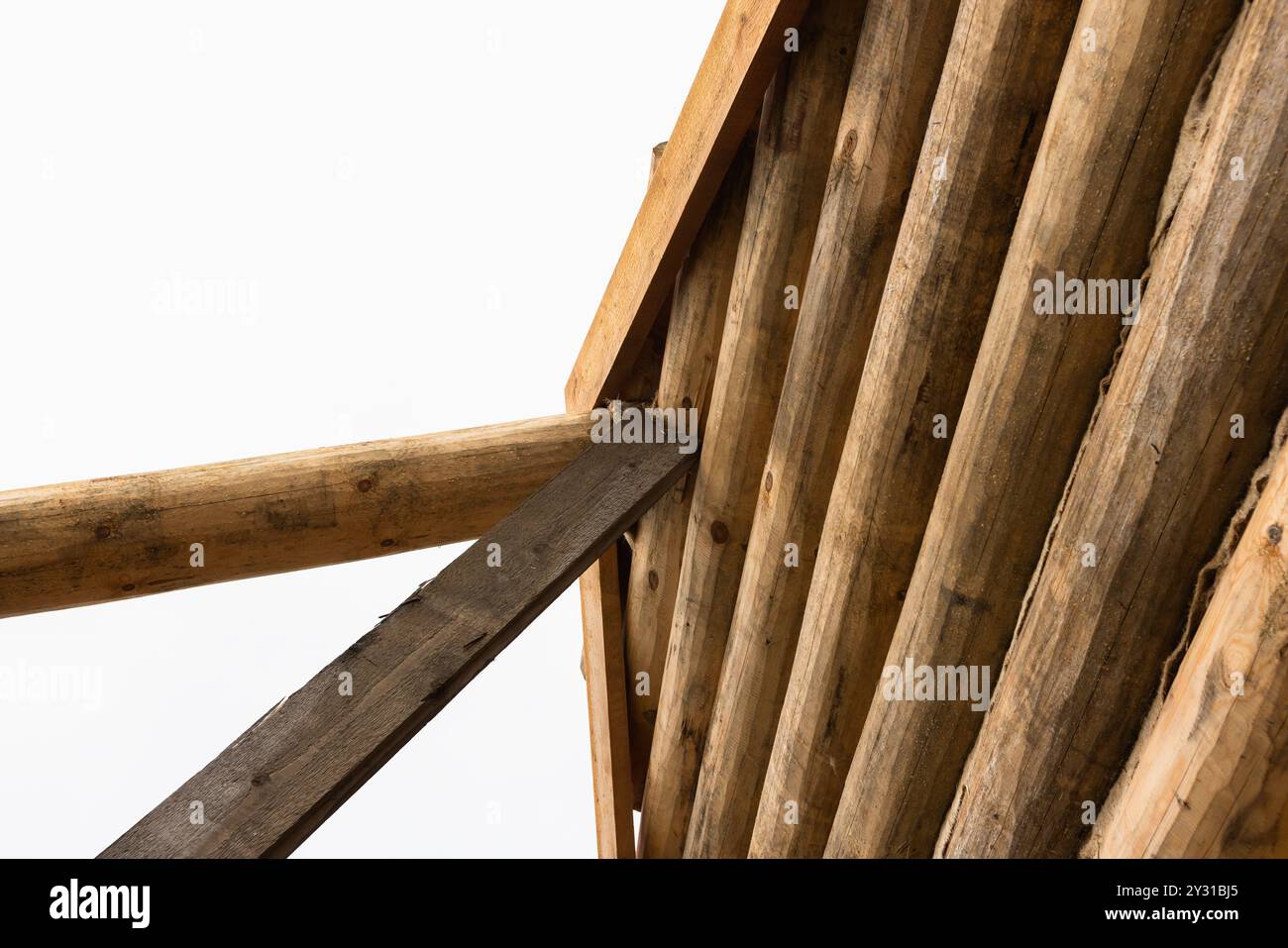 Ländliches Holzhaus aus Baumstämmen ist im Bau, Holzteile Wand ist unter hellem Himmel Stockfoto