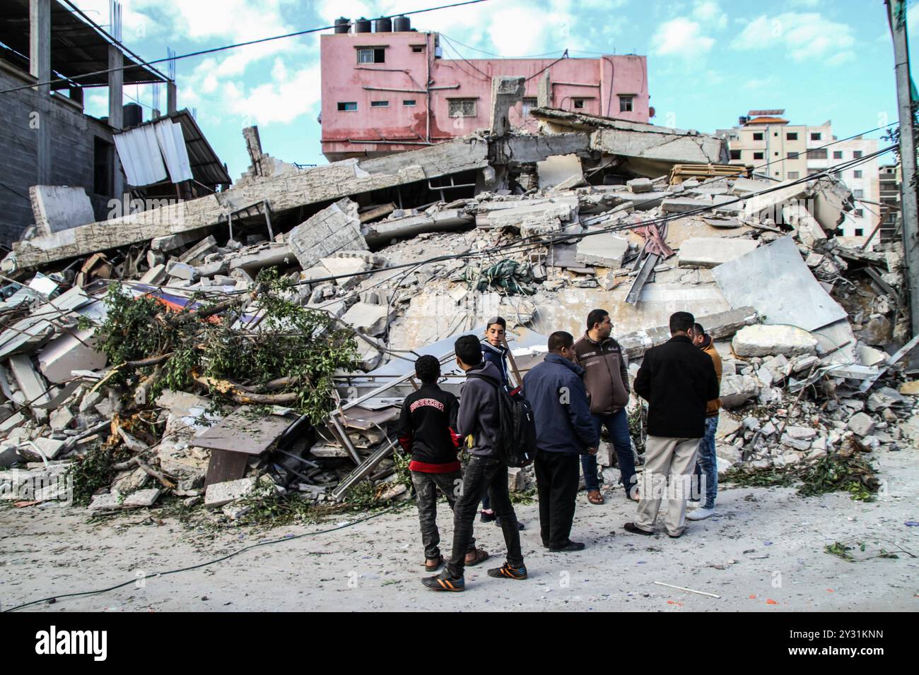 Gaza, Palästina, 26. März 2019. Die Palästinenser bewerten die Schäden am Standort des Multazim-Versicherungsgebäudes, das am 25. März durch israelische Bombardements im Osten von Gaza-Stadt zerstört wurde. Israelische Kampfflugzeuge führten Dutzende von Luftangriffen im südlichen, mittleren und nördlichen Gazastreifen durch, nachdem eine Gaza-Rakete ein israelisches Haus nördlich von Tel Aviv in Zentralisrael getroffen hatte und sieben Israelis verletzt hatte. Israelische Kampfflugzeuge zielten auf Standorte der Hamas sowie Dutzende Wohn- und Geschäftsgebäude ab, und laut dem palästinensischen Gesundheitsministerium in Gaza leiden sieben Palästinenser Stockfoto