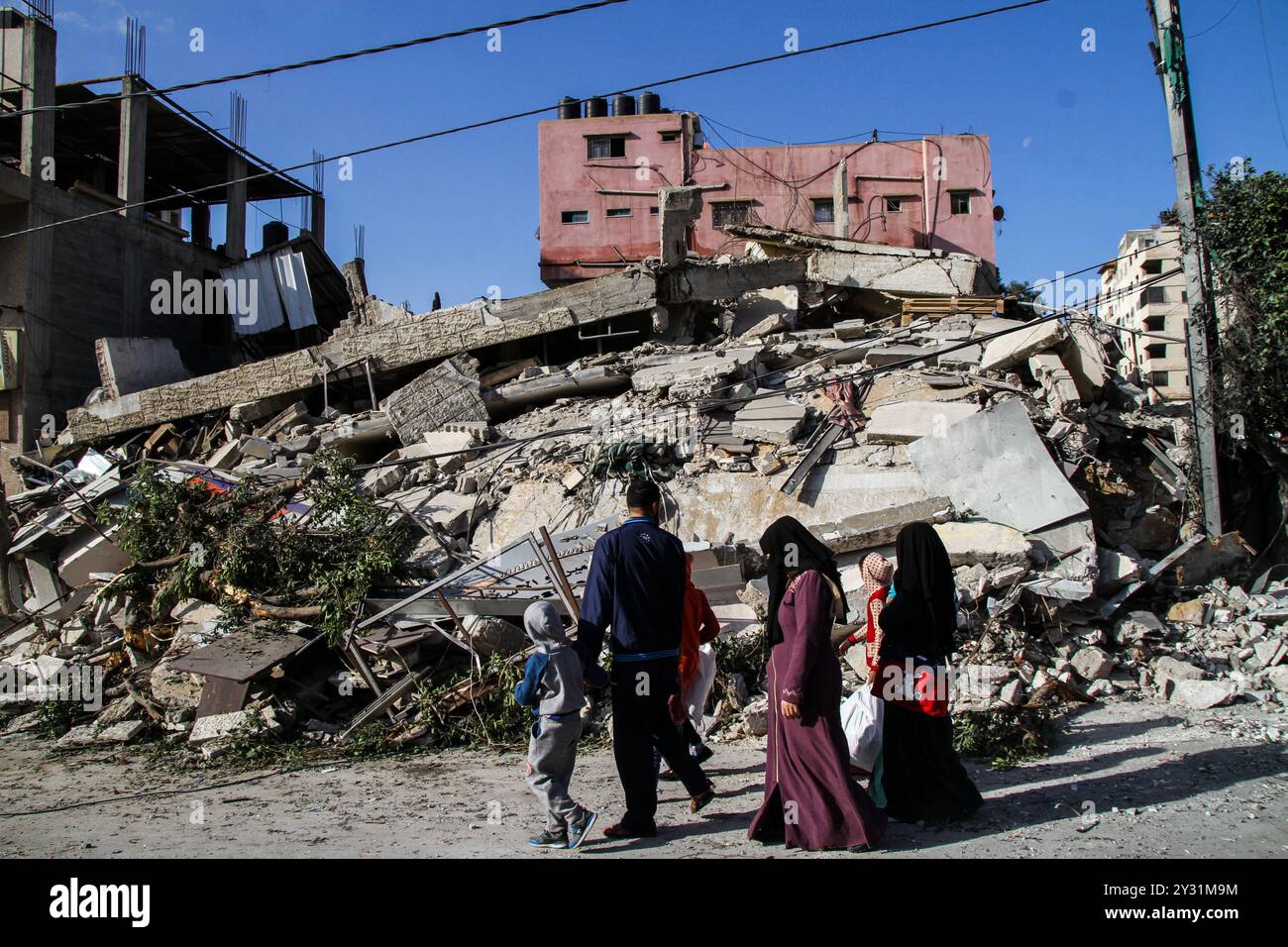 Gaza, Palästina, 26. März 2019. Die Palästinenser bewerten die Schäden am Standort des Multazim-Versicherungsgebäudes, das am 25. März durch israelische Bombardements im Osten von Gaza-Stadt zerstört wurde. Israelische Kampfflugzeuge führten Dutzende von Luftangriffen im südlichen, mittleren und nördlichen Gazastreifen durch, nachdem eine Gaza-Rakete ein israelisches Haus nördlich von Tel Aviv in Zentralisrael getroffen hatte und sieben Israelis verletzt hatte. Israelische Kampfflugzeuge zielten auf Standorte der Hamas sowie Dutzende Wohn- und Geschäftsgebäude ab, und laut dem palästinensischen Gesundheitsministerium in Gaza leiden sieben Palästinenser Stockfoto