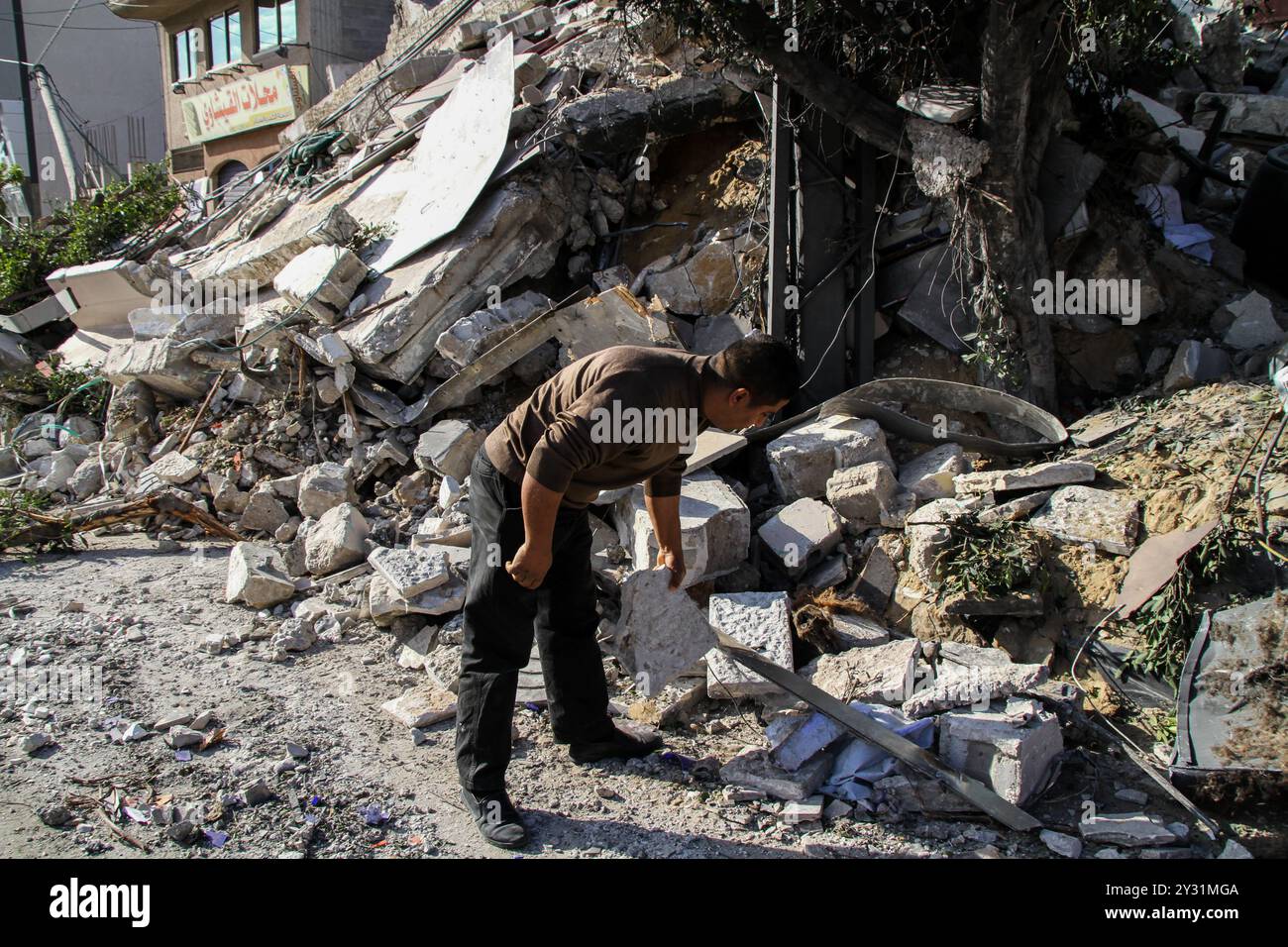 Gaza, Palästina, 26. März 2019. Die Palästinenser bewerten die Schäden am Standort des Multazim-Versicherungsgebäudes, das am 25. März durch israelische Bombardements im Osten von Gaza-Stadt zerstört wurde. Israelische Kampfflugzeuge führten Dutzende von Luftangriffen im südlichen, mittleren und nördlichen Gazastreifen durch, nachdem eine Gaza-Rakete ein israelisches Haus nördlich von Tel Aviv in Zentralisrael getroffen hatte und sieben Israelis verletzt hatte. Israelische Kampfflugzeuge zielten auf Standorte der Hamas sowie Dutzende Wohn- und Geschäftsgebäude ab, und laut dem palästinensischen Gesundheitsministerium in Gaza leiden sieben Palästinenser Stockfoto