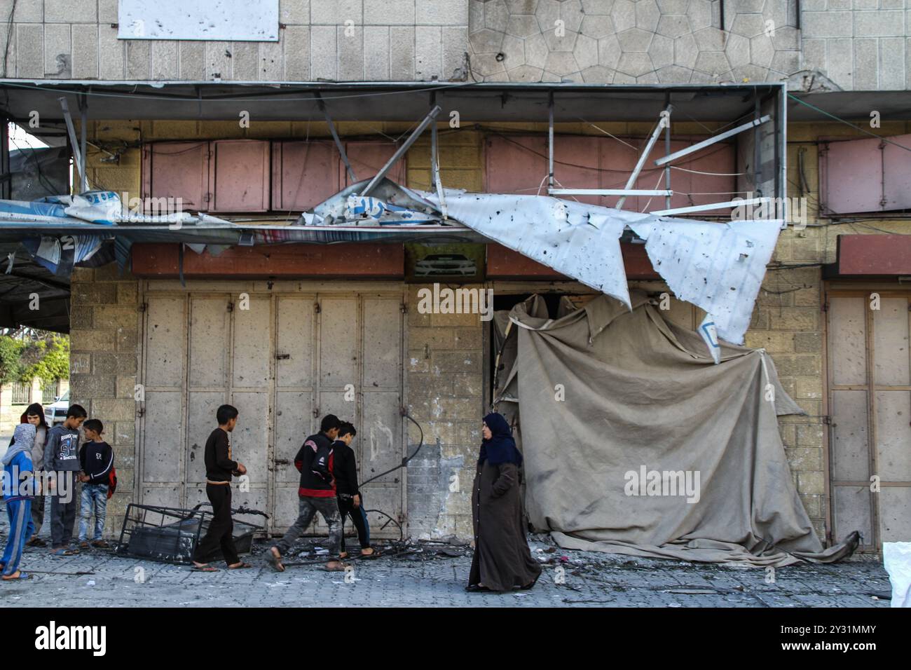 Gaza, Palästina, 26. März 2019. Die Palästinenser bewerten die Schäden am Standort des Multazim-Versicherungsgebäudes, das am 25. März durch israelische Bombardements im Osten von Gaza-Stadt zerstört wurde. Israelische Kampfflugzeuge führten Dutzende von Luftangriffen im südlichen, mittleren und nördlichen Gazastreifen durch, nachdem eine Gaza-Rakete ein israelisches Haus nördlich von Tel Aviv in Zentralisrael getroffen hatte und sieben Israelis verletzt hatte. Israelische Kampfflugzeuge zielten auf Standorte der Hamas sowie Dutzende Wohn- und Geschäftsgebäude ab, und laut dem palästinensischen Gesundheitsministerium in Gaza leiden sieben Palästinenser Stockfoto