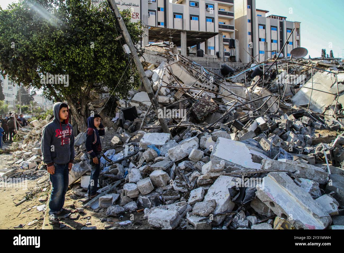 Gaza, Palästina, 26. März 2019. Die Palästinenser bewerten die Schäden am Standort des Multazim-Versicherungsgebäudes, das am 25. März durch israelische Bombardements im Osten von Gaza-Stadt zerstört wurde. Israelische Kampfflugzeuge führten Dutzende von Luftangriffen im südlichen, mittleren und nördlichen Gazastreifen durch, nachdem eine Gaza-Rakete ein israelisches Haus nördlich von Tel Aviv in Zentralisrael getroffen hatte und sieben Israelis verletzt hatte. Israelische Kampfflugzeuge zielten auf Standorte der Hamas sowie Dutzende Wohn- und Geschäftsgebäude ab, und laut dem palästinensischen Gesundheitsministerium in Gaza leiden sieben Palästinenser Stockfoto