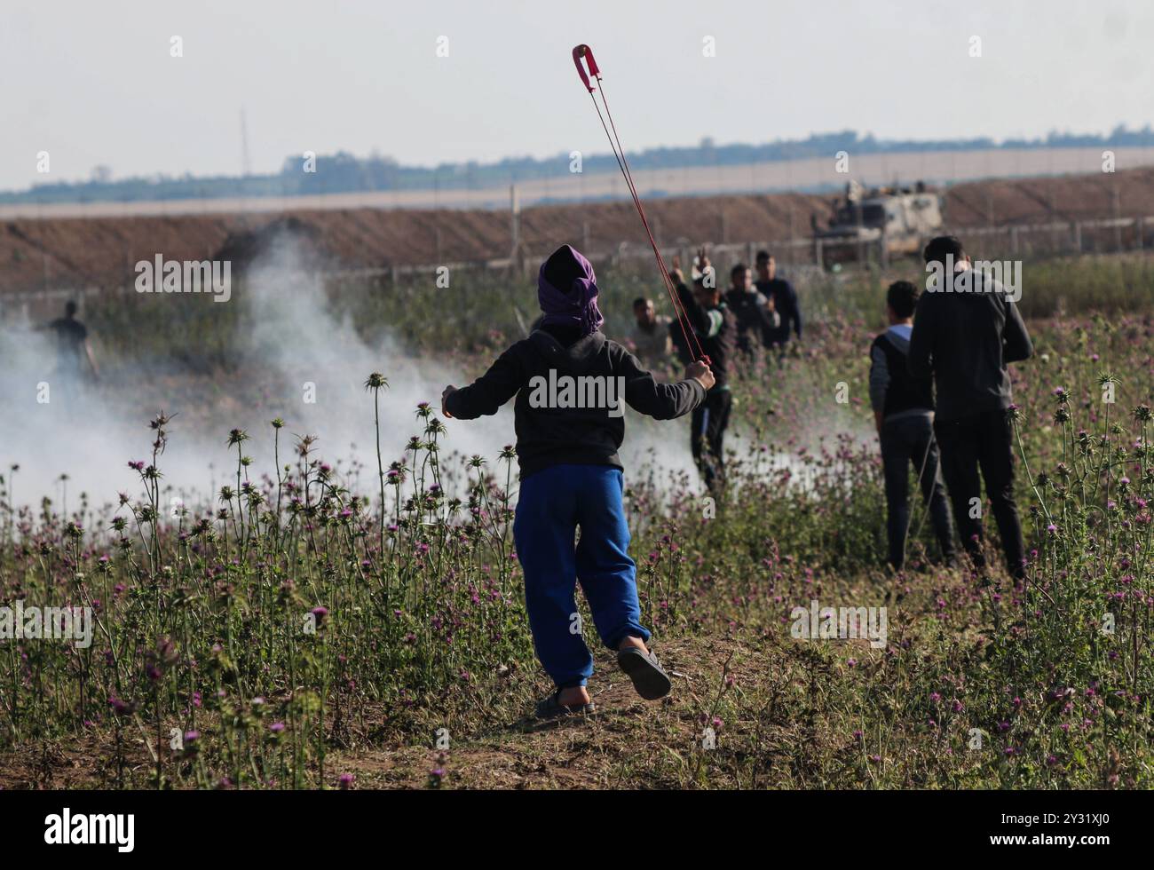 Gaza, Palästina, 5. April 2019. Palästinensische Demonstranten stoßen an diesem Freitag im Gebiet von Abu Safiya im Norden des Gazastreifens an der Grenze zu Israel auf israelische Truppen. Tausende Palästinenser nahmen an der Kundgebung an fünf Hauptstandorten entlang der Grenze des Gazastreifens zu Israel Teil. Einige Palästinenser warfen Steine auf die israelischen Soldaten auf der anderen Seite des Zauns, die Tränengaskanister, Gummigeschosse und lebende Schüsse auf Demonstranten abfeuerten, bei denen einige von ihnen verletzt wurden. Eine große Anzahl von Sanitätern war an den Standorten anwesend, um die zu unterstützen Stockfoto