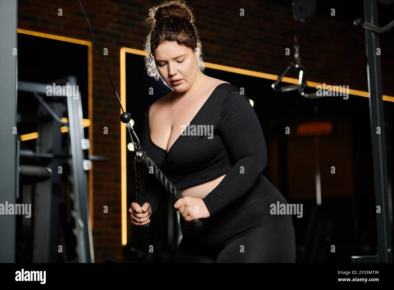 Eine Frau in Übergröße übt selbstbewusst ihre aktive Kleidung aus und zeigt Stärke und Entschlossenheit. Stockfoto