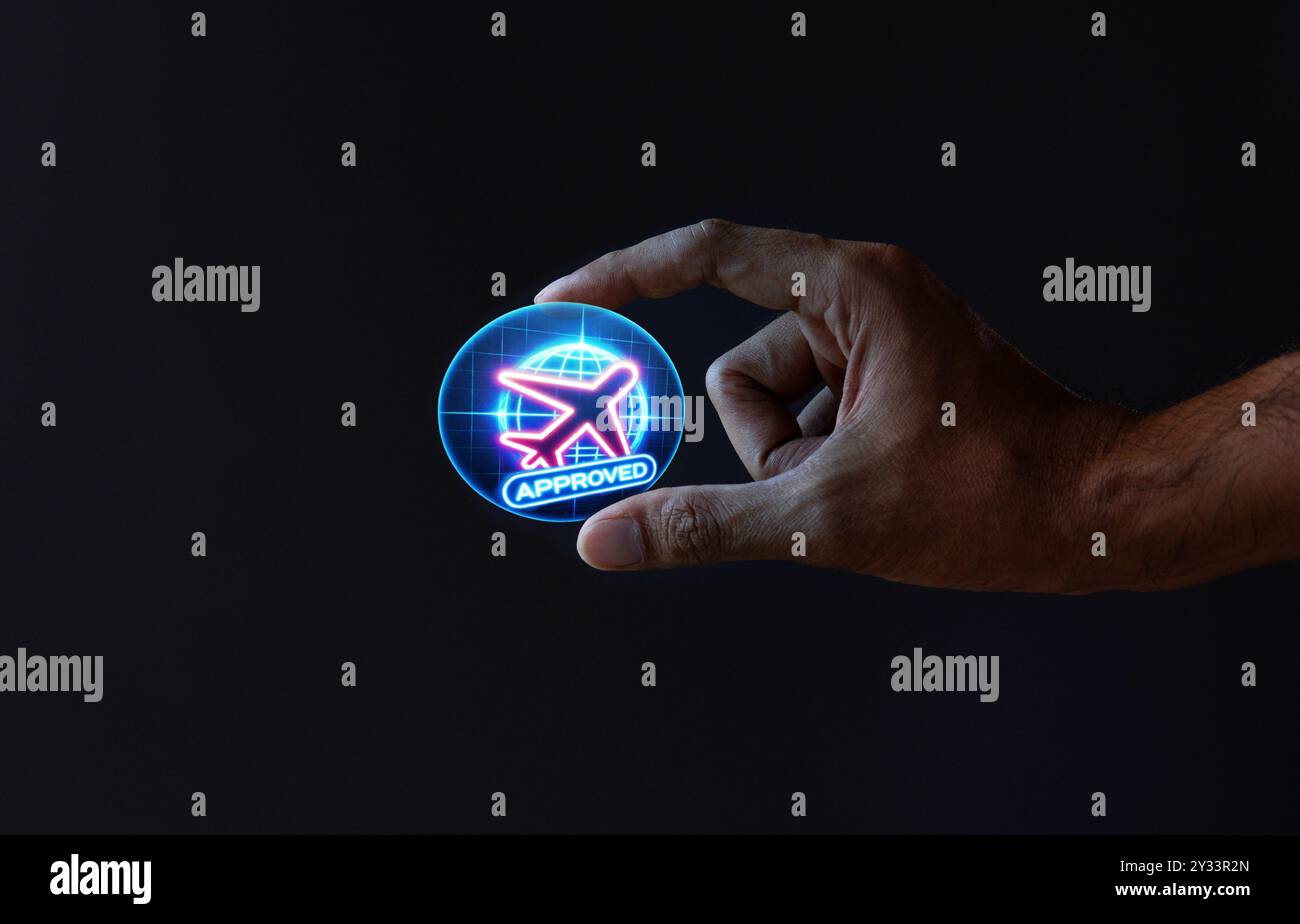 Eine Hand, die eine digitale holographische Projektion einer blauen Reisegenehmigung mit einem Flugzeugsymbol und dem Wort ‚GENEHMIGT‘ hält. Digitale Reisegenehmigung, Stockfoto
