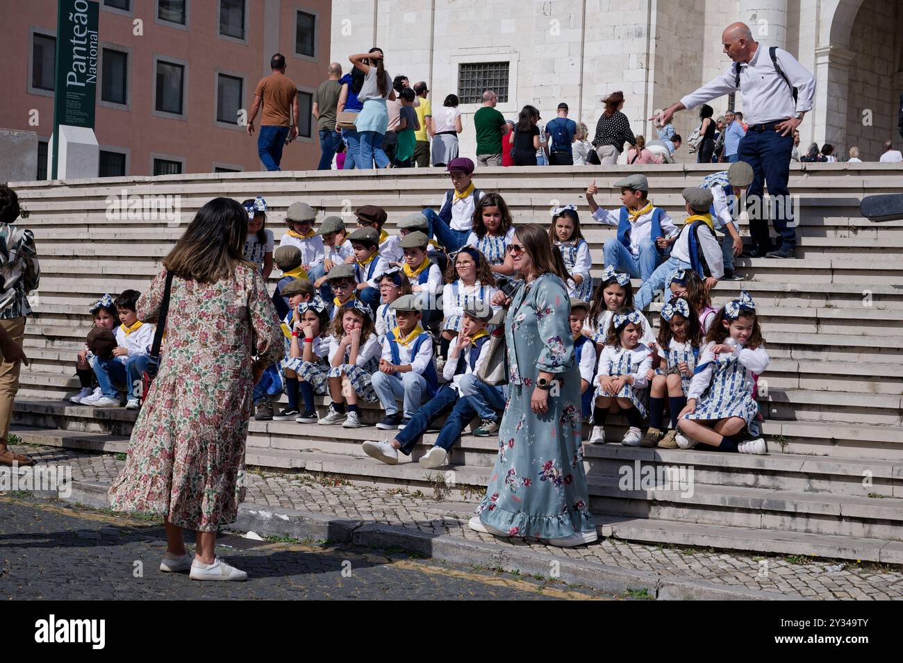 Eine Gruppe von Kindern in traditioneller portugiesischer Kleidung sitzt auf den Stufen des Panteão Nacional und posiert für ein Foto Stockfoto