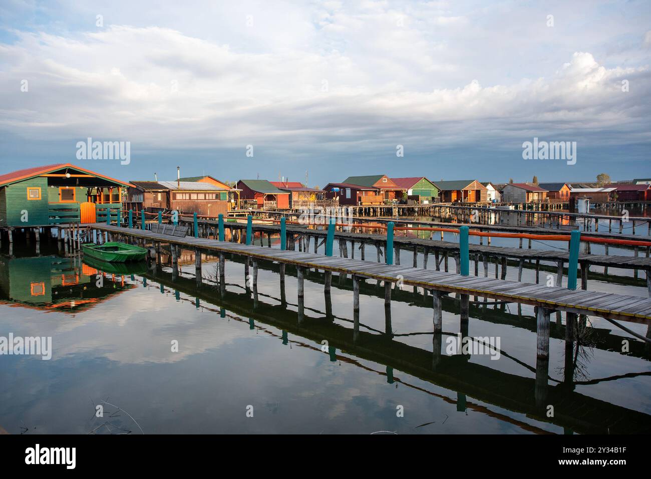 Oroszlany, Ungarn. September 2024. Reflexionen der Gebäude im Wasser und stürmische Wolken am frühen Morgen über dem schwimmenden Dorf Bokodi. Der Bodoki-See ist ein künstlicher See in Oroszlany, Ungarn. Sie wurde 1961 von der Oroszlany Thermal Power Company gegründet. Die Häuser stehen über dem Wasser auf Stelzen. Im Laufe der Jahre wurde der Bokodi-See zu einem beliebten Angelplatz und Ort für Fotografen. (Foto: Krisztian Elek/SOPA Images/SIPA USA) Credit: SIPA USA/Alamy Live News Stockfoto