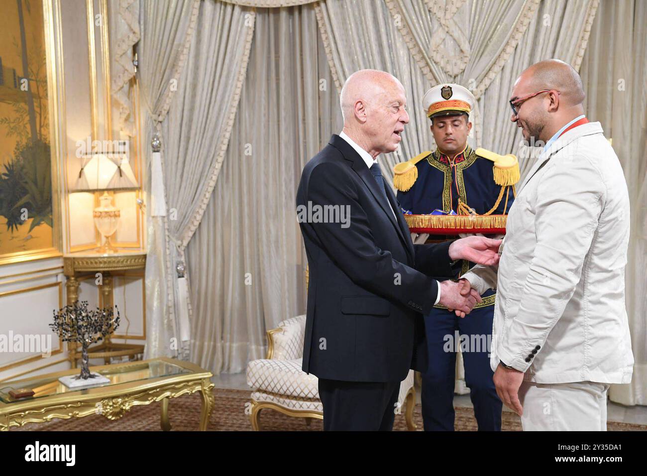 Der tunesische Präsident Kais Saied ehrt den Meister Rawaa Tlili, der bei den Paralympischen Spielen in Paris 2024 eine Goldmedaille im Kugelstoßen und eine Goldmedaille im Diskuswurf gewann, sowie den Champion Walid Ktila, der im 100-m-Rollstuhl eine Silbermedaille gewann. Der tunesische Präsident von Karthago, Kais Saied, ehrt den Meister Rawaa Tlili, der bei den Paralympischen Spielen in Paris 2024 eine Goldmedaille im Kugelstoßen und eine Goldmedaille im Diskuswurf gewann, und ehrt auch den Champion Walid Ktila, der im 100-m-Rollstuhl eine Silbermedaille gewann. Carthage Palace, Tunis, am 11. September 2024. Foto: Tunesischer Ratsvorsitz apaimages Tunis Tunis Tu Stockfoto