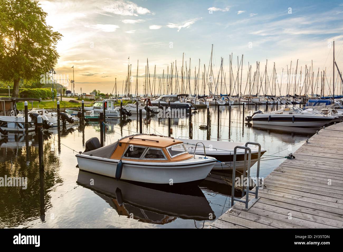 Boote in einem Jachthafen (Langballigau) während des wunderschönen Sonnenuntergangs an der Ostsee in Norddeutschland Stockfoto
