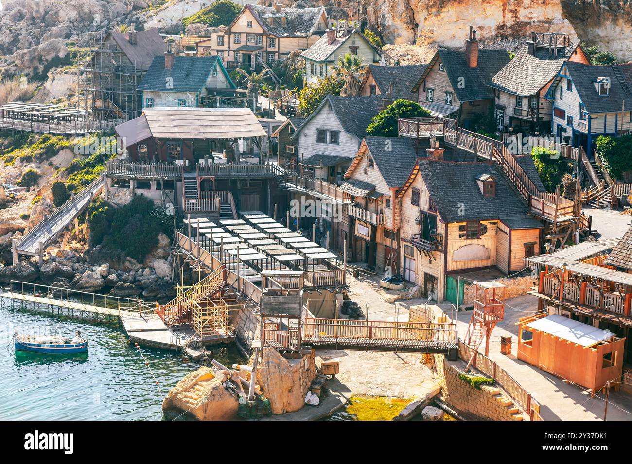Kleine Küstenstadt mit bezaubernden Häusern und farbenfrohen Booten entlang der ruhigen Uferpromenade. Popeye Village auf Malta Stockfoto