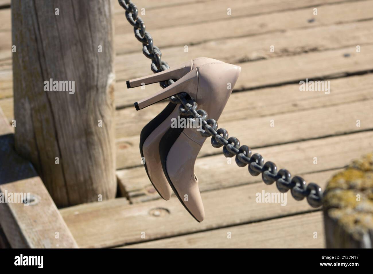 Beige Absätze hängen an einem Kettenseil auf einer Brücke Stockfoto