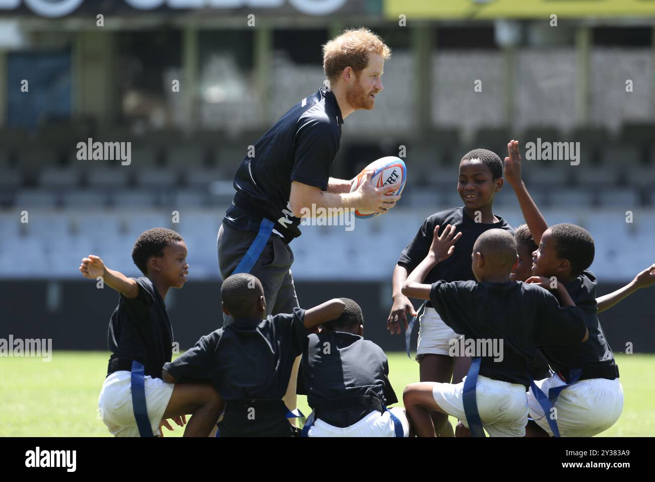 Aktenfoto des Herzogs von Sussex im Alter von 31 Jahren. Aktenfoto vom 12/15: Prinz Harry spielt Tag Rugby mit Kindern im Kings Park Stadium, während er mit Mitgliedern des Sharks Rugby-Teams auf dem Spielfeld in Durban an einem Training und einer Skills-Session mit Trainern und jungen Spielern im Rahmen seines Besuchs in Südafrika teilnimmt. Der Herzog von Sussex feiert am Sonntag seinen 40. Geburtstag. Ausgabedatum: Freitag, 13. September 2024. Stockfoto