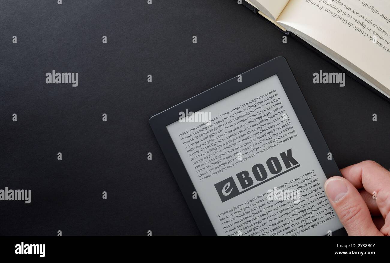 E-Book-Lesekonzept mit Hand haltendem E-Book auf schwarzem Tisch und offenem traditionellem Papierbuch. Draufsicht Stockfoto