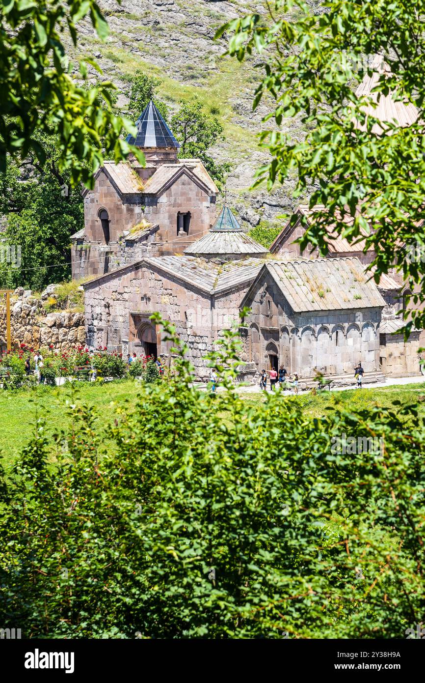 Gosh, Armenien - 6. Juli 2024: Blick auf die Kirchen des Goschavank-Klosters durch grüne Blätter, Armenien am sonnigen Sommertag von der St. Gevorg-Kirche Stockfoto