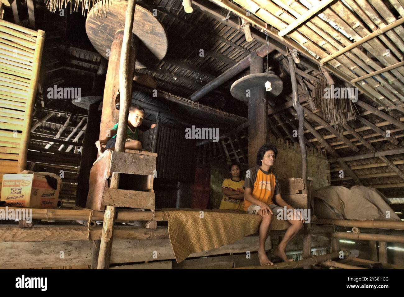 Umbu Tiu, ein Dorfbewohner, mit seiner Frau und seinem Kind in ihrem traditionellen Haus im traditionellen Dorf Praijing in Tebara, Waikabubak, West Sumba, East Nusa Tenggara, Indonesien. Auf einer Tagung der Generalversammlung im Dezember 2023 haben die Vereinten Nationen ihre Besorgnis über die Veruntreuung und den Missbrauch des kulturellen Erbes der indigenen Völker zum Ausdruck gebracht. Die Vereinten Nationen bekräftigen, dass die indigenen Völker das Recht haben, ihr kulturelles Erbe, ihr traditionelles Wissen und ihre traditionellen kulturellen Ausdrucksformen zu erhalten, zu kontrollieren, zu schützen und zu entwickeln. Stockfoto