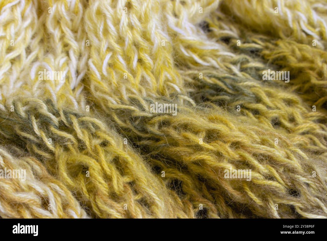Verlaufender gestrickter Hintergrund. Zitronenfarbene Alpaka- und Wollfäden mit wunderschönem Strickmuster. Verlaufende Häkelarbeit in warmen Farben. Strickhobbyarbeit. Stockfoto