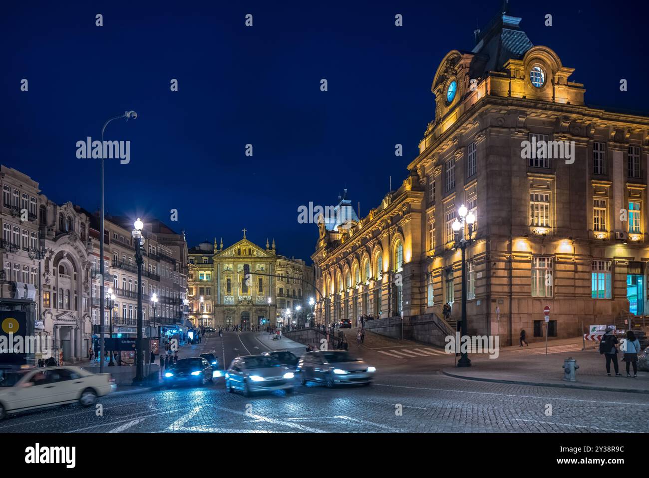 Abendliche Szene der Straße Rua das Flores mit dem Bahnhof Sao Bento und der Kirche Sao Antonio dos Congregados in Porto, Portugal, mit Beleuchtung Stockfoto