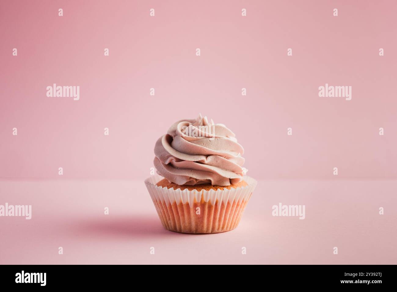 Ein rosafarbener Cupcake mit Zuckerguss Stockfoto