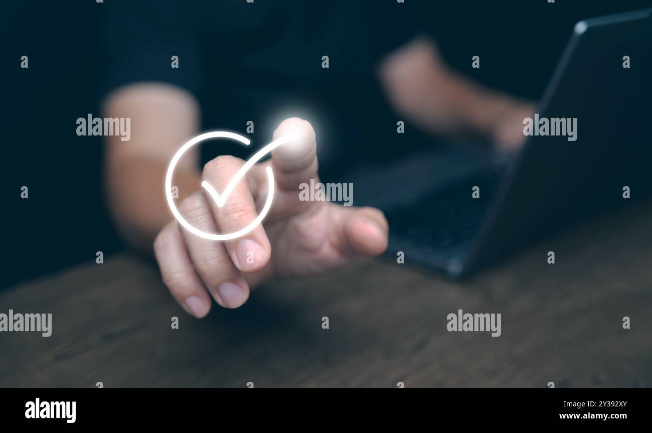 Der Finger eines Mannes, der auf das richtige Zeichen tippt, was eine Genehmigung für das Dokument, das Geschäftsprojekt und die Bewertung oder Bewertung darstellt Stockfoto
