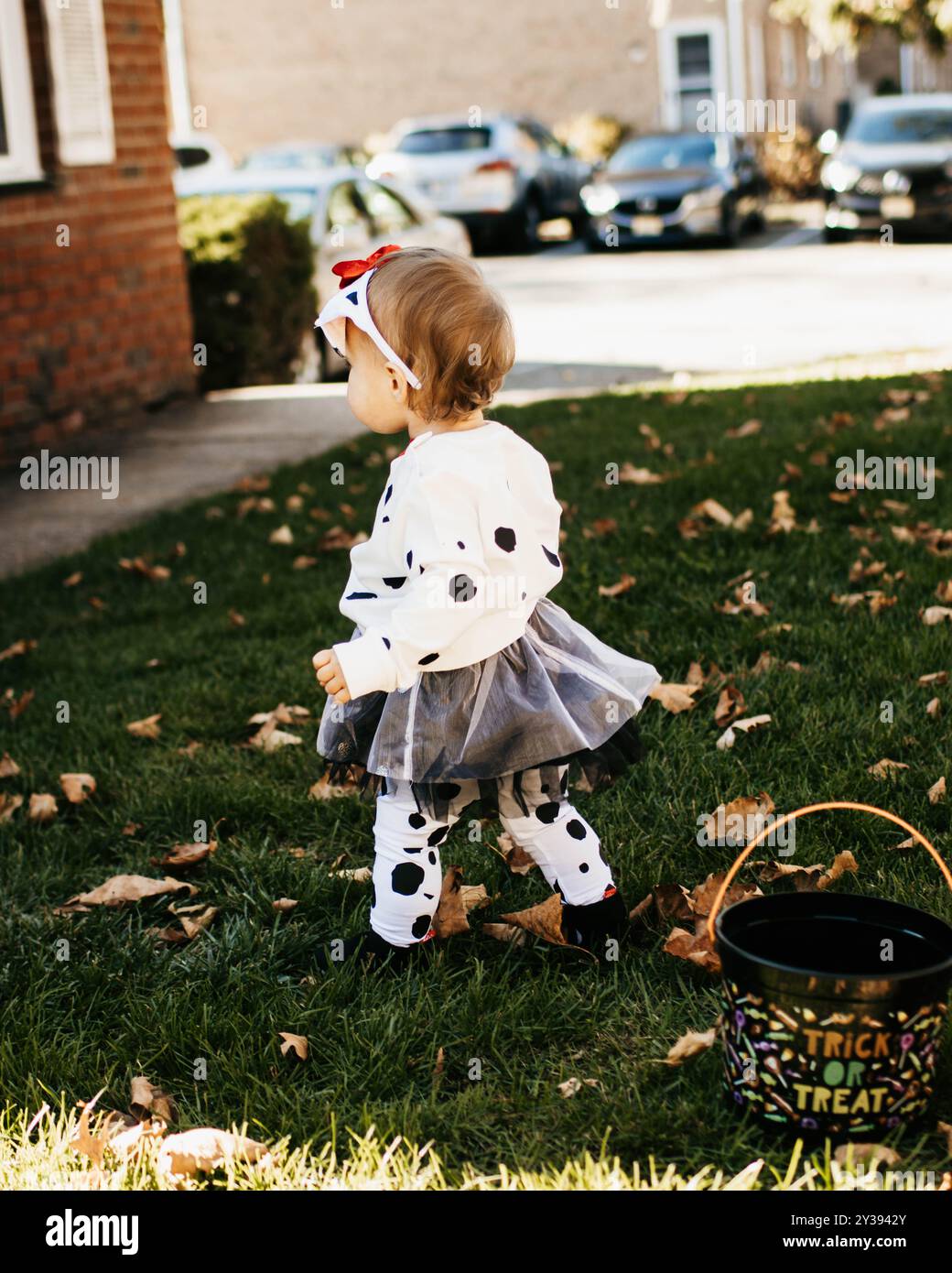 Kleinkind Mädchen im Kostüm, das an Halloween über Herbstlaub geht Stockfoto