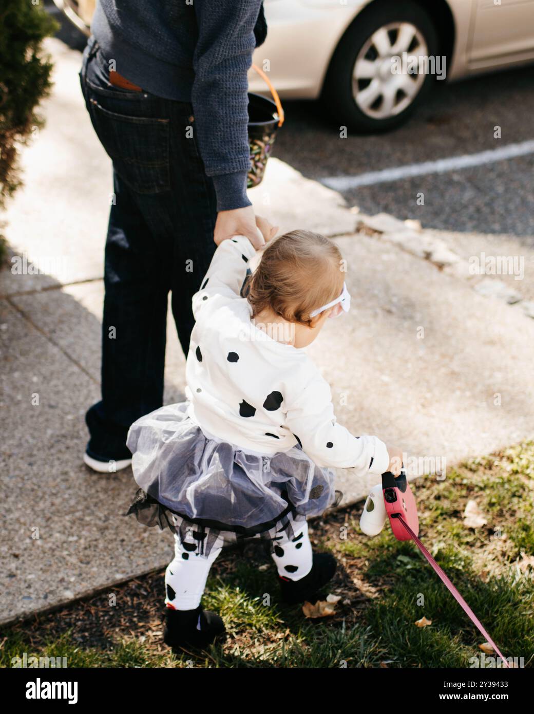 Vater und Tochter, die zu Halloween gekleidet sind und Hundeleine halten Stockfoto