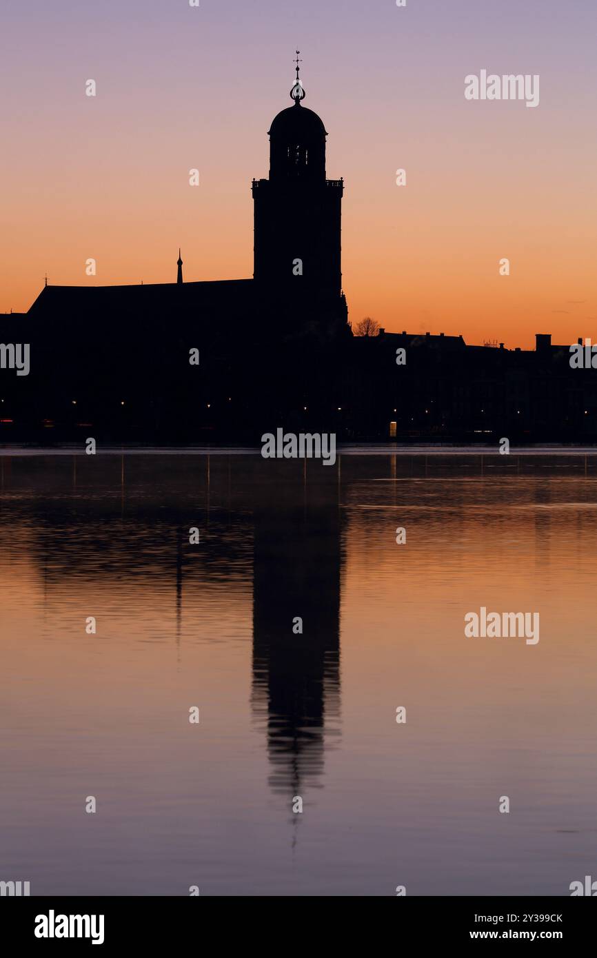 Die große Kirche in Deventer, Niederlande, mit Reflexion im Fluss IJssel bei Sonnenaufgang Stockfoto