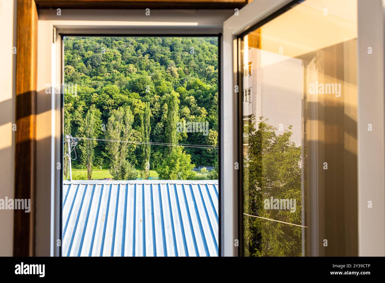 Blick auf Dach und Wald durch offenes Fenster am sonnigen Sommertag in Dilijan, Armenien Stockfoto