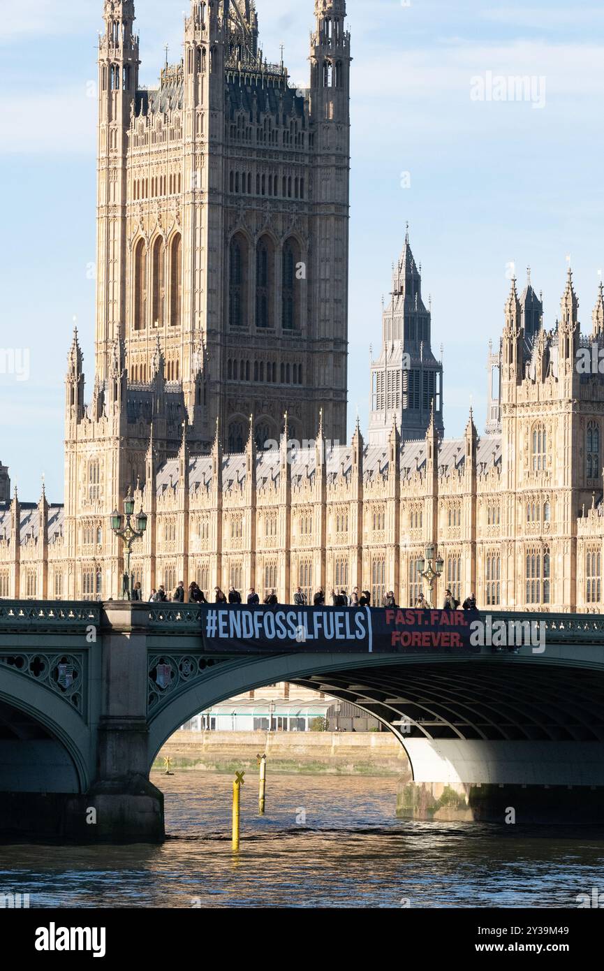 London, Großbritannien. 13. September 2024. Über der Westminster Bridge, von den Houses of Parliament, wird ein großes Banner geworfen, auf dem erklärt wird, dass es die größte globale Aktion überhaupt ist, um von den Regierungen zu fordern, dass sie daran arbeiten, die Verwendung fossiler Brennstoffe zu beenden. In der Aktionswoche vom 13. Bis 20. September wird die Kampagne „Global Fight to End fossile Brennstoffe“ mit der Kampagne „Pay Up for Climate Finance“ zusammengeführt, um einen gerechten und gerechten Ausstieg aus fossilen Brennstoffen als notwendiges Mittel zur Bekämpfung der Bedrohungen durch die globale Heizung zu fordern. Quelle: Ron Fassbender/Alamy Live News Stockfoto