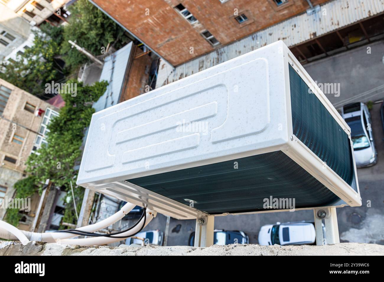 Über dem Fenster der Wohnung auf die Klimaanlage, die an der Wand des Wohngebäudes über dem Innenhof der Stadt Jerewan, Armenien im Sommer installiert ist Stockfoto