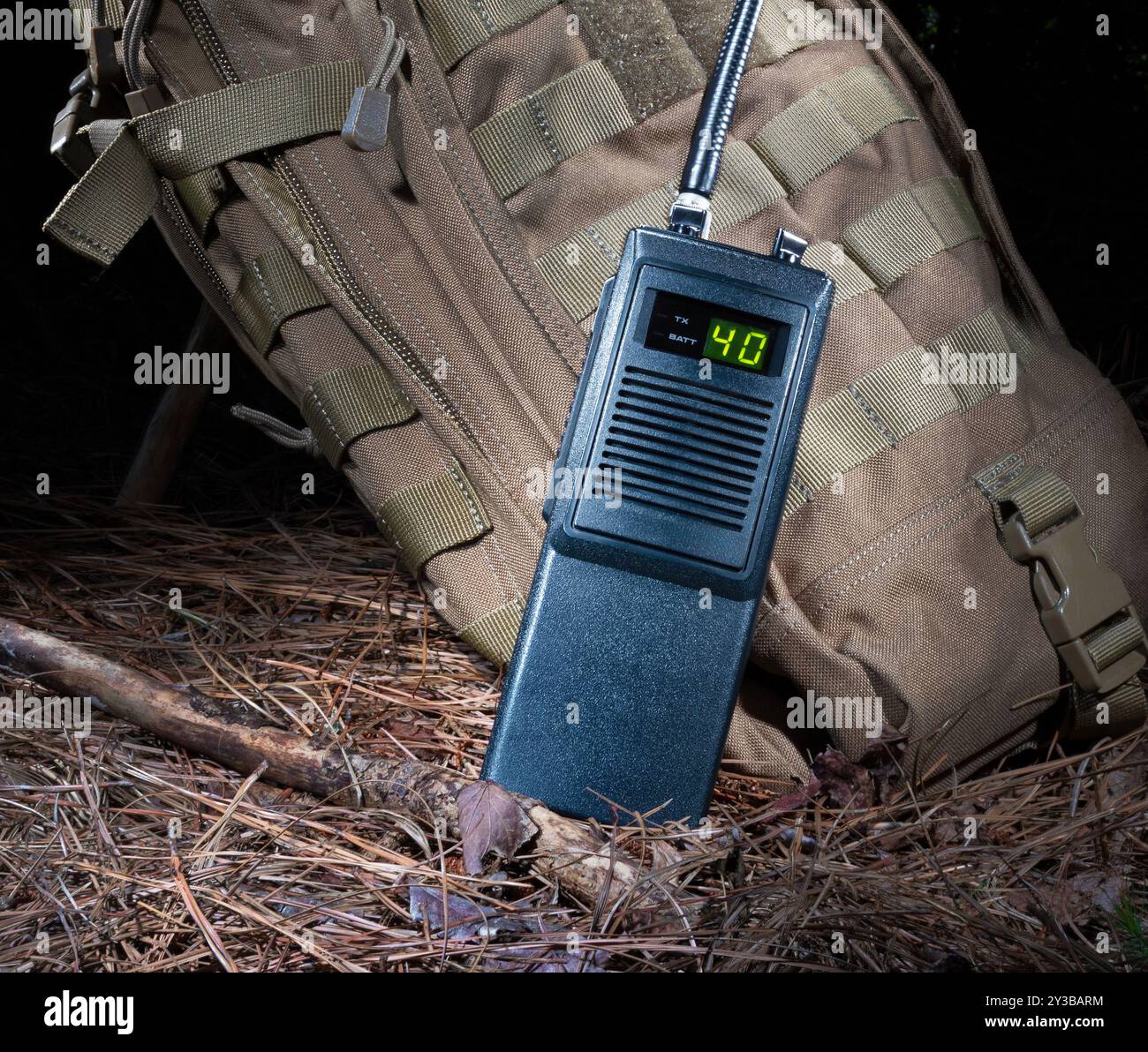 CB Radio Walkie spricht auf einem braunen Rucksack in einem dunklen Waldboden. Stockfoto