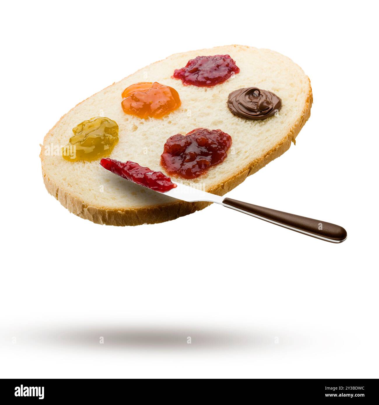 Scheibe Weißbrot mit verschiedenen Marmeladen und Messer fliegen auf weißem Hintergrund. Stockfoto