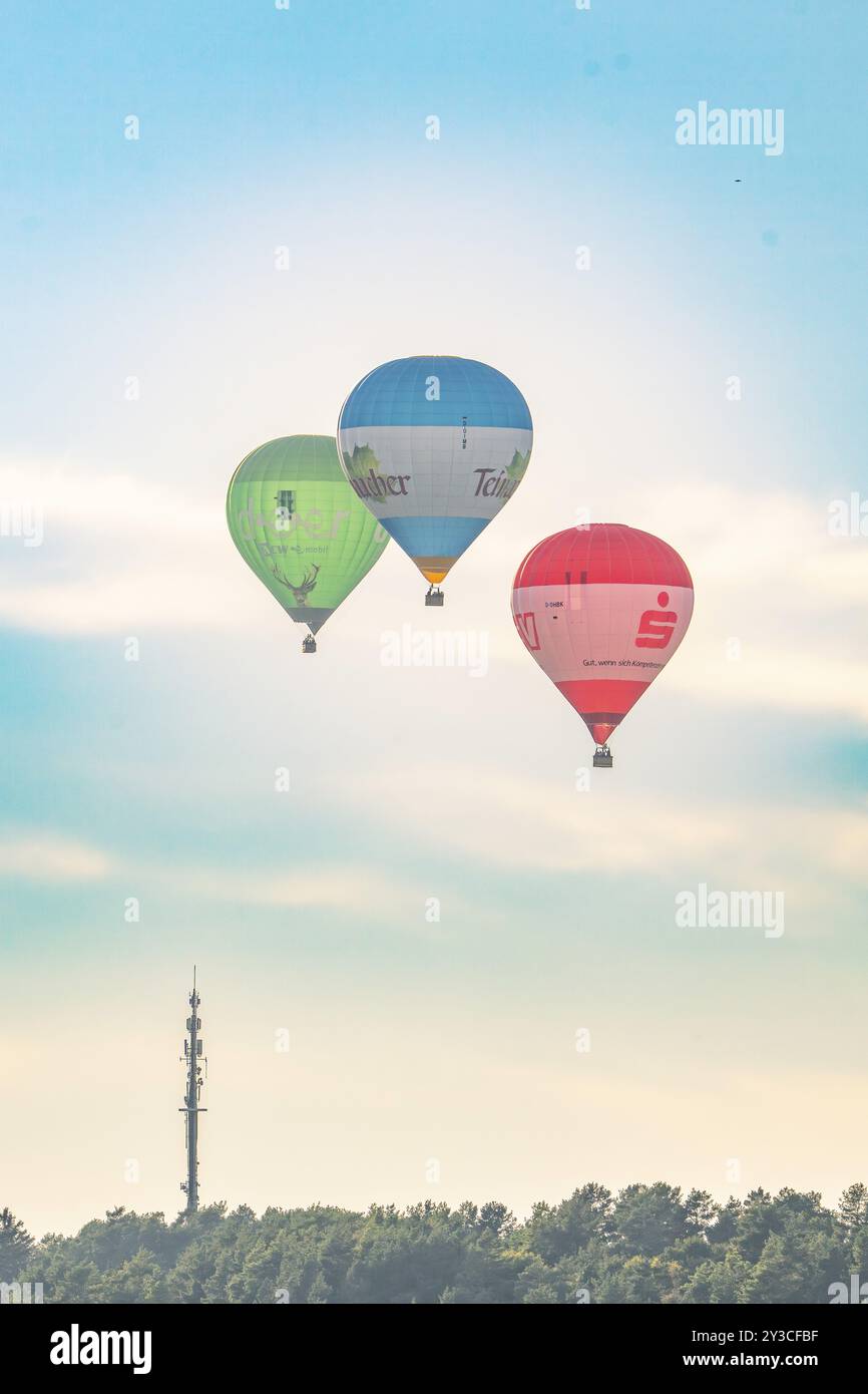 Drei Heißluftballons fliegen an einem ruhigen Tag in der Nähe eines Antennenturms, Calw, Schwarzwald, Deutschland, Europa Stockfoto