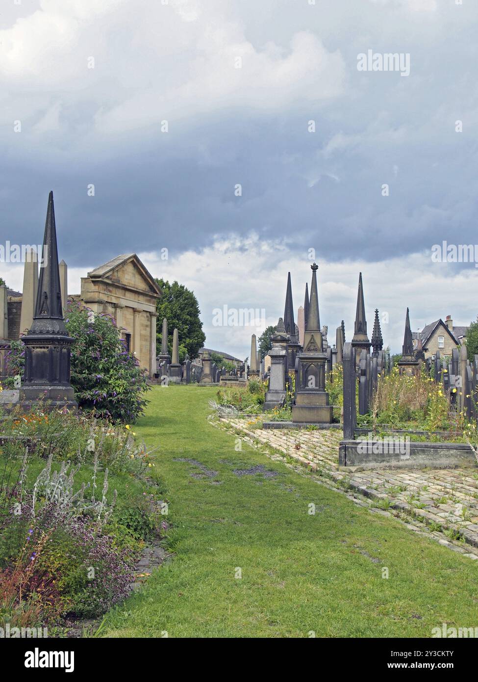 Im Stil der Gotik gestaltete Grabsteine aus dem 19. Jahrhundert, umgeben von Wildblumen auf dem ehemaligen Friedhof der Lüster in halifax, heute ein öffentlicher Park Stockfoto