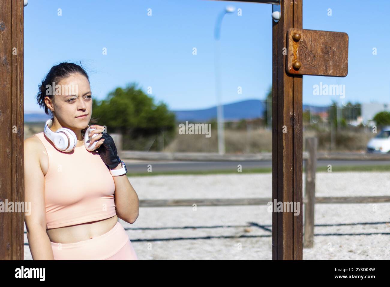 Junge Frau, die nach einer Runde Übung in einem Langhantelpark ruht, horizontales Porträt von der Taille nach oben Stockfoto