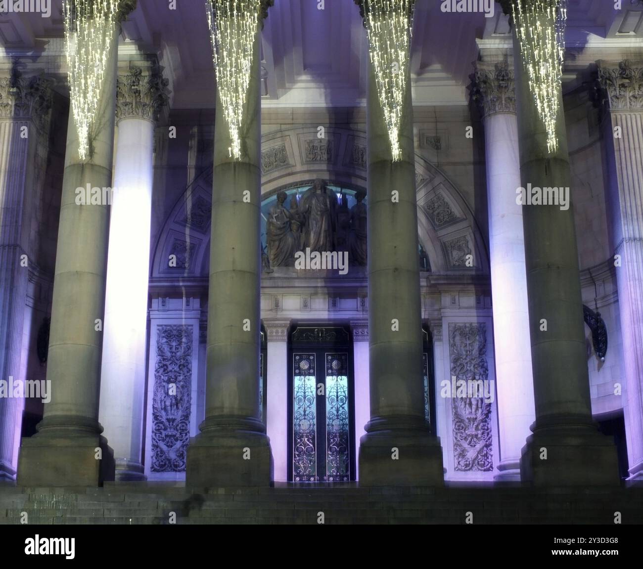 Der Eingang und die Säulen der Leeds Town Hall in West yorkshire beleuchtet bei Nacht Stockfoto